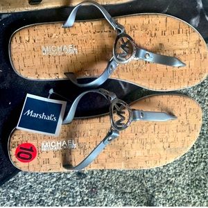 Silver pair of Michael Kors flip flop sandal